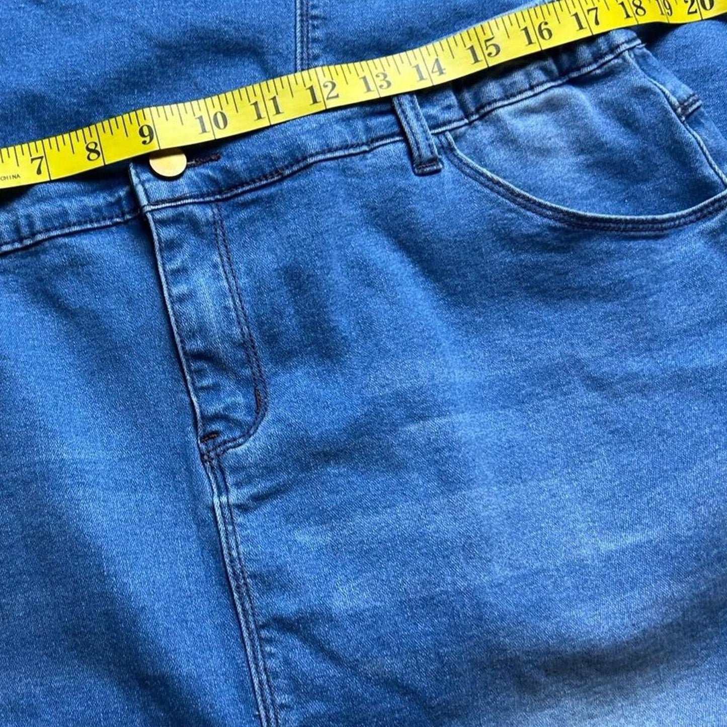 Blue jeans with a yellow measuring tape around the waist