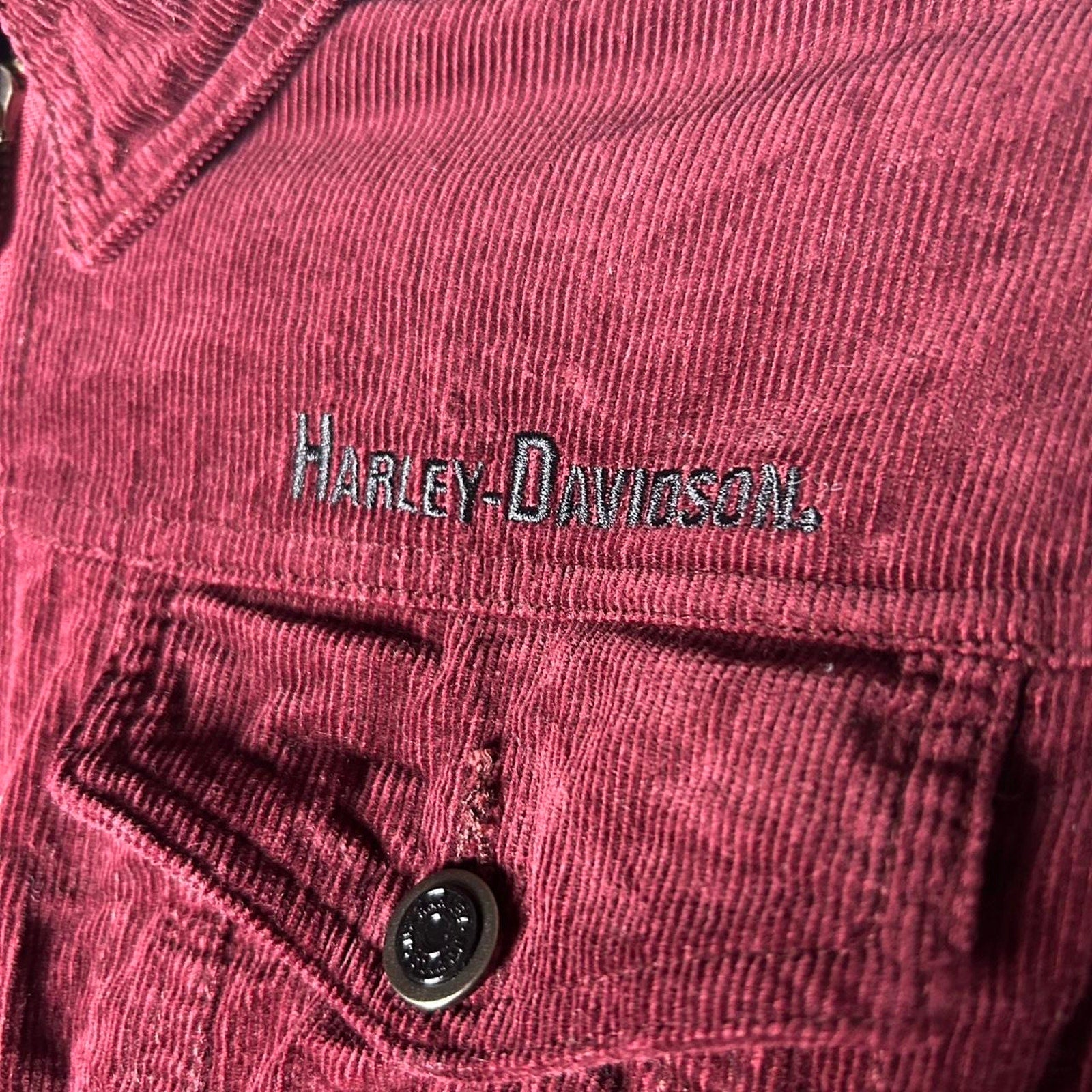 Close-up of a maroon corduroy jacket with Harley-Davidson logo.